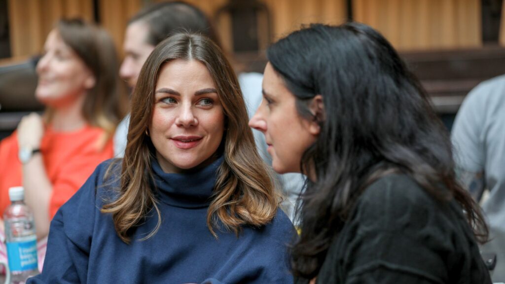 two women at corporate event in conversation.